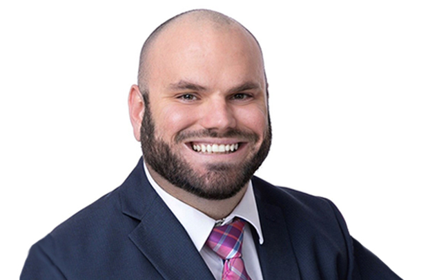 Selective Property Claims Specialist Dakota Cane smiling and wearing a business suit.